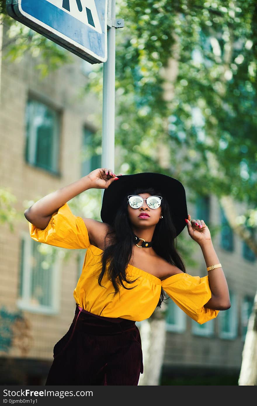 Woman in Black Hat and Yellow Top Taking Selfie