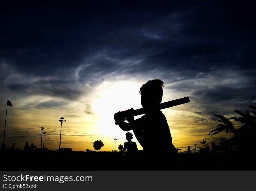 Silhouette of Person Holding Stick