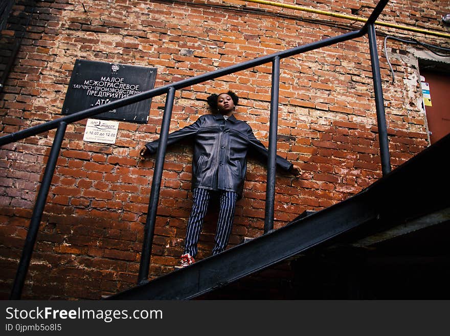 Woman in Black Jacket Standing on the Stairs