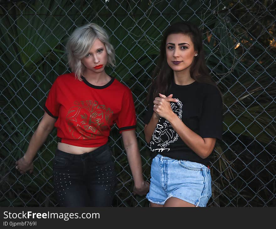 Two Woman Leaning on Fence