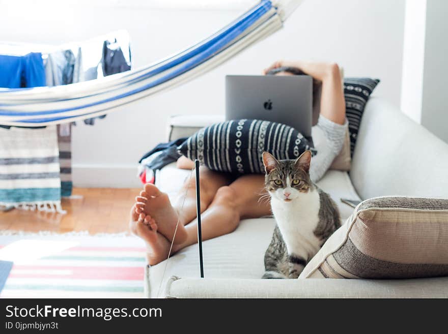 Woman Lying on Sofa With Cat in Her Foot