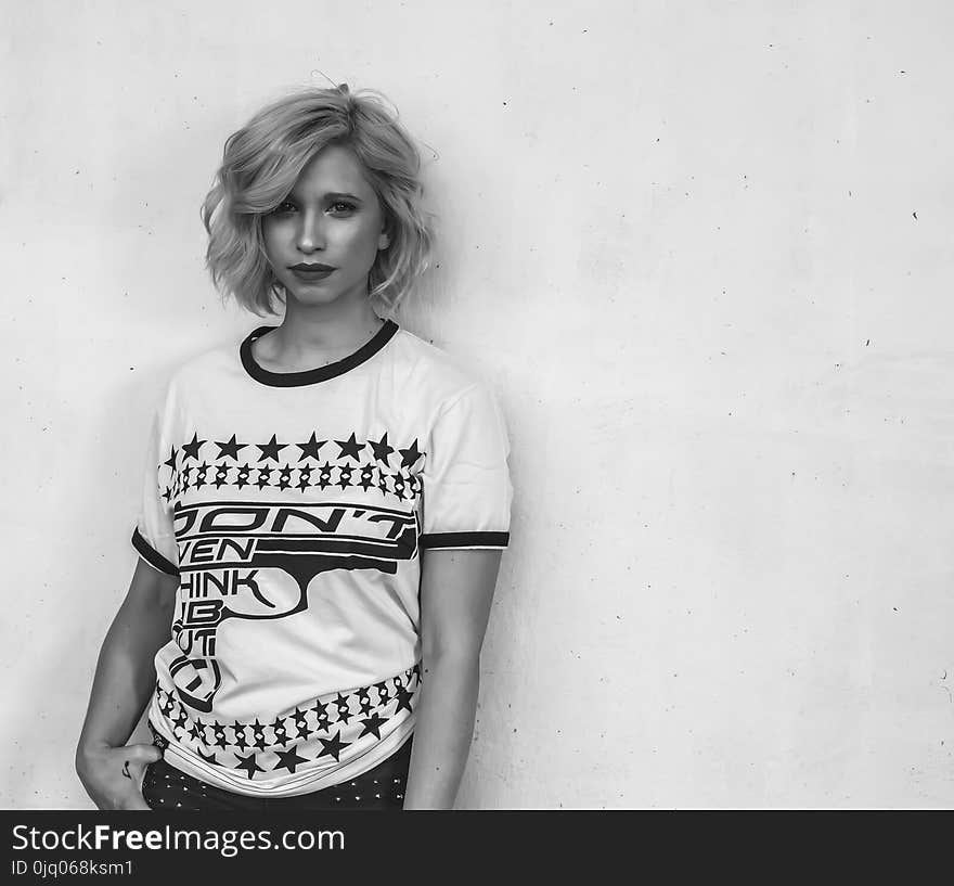 Woman Wearing White Labeled Shirt in Grayscale Photography