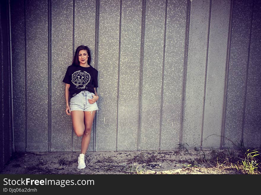 Woman Wearing Black Shirt Leaning on Wall