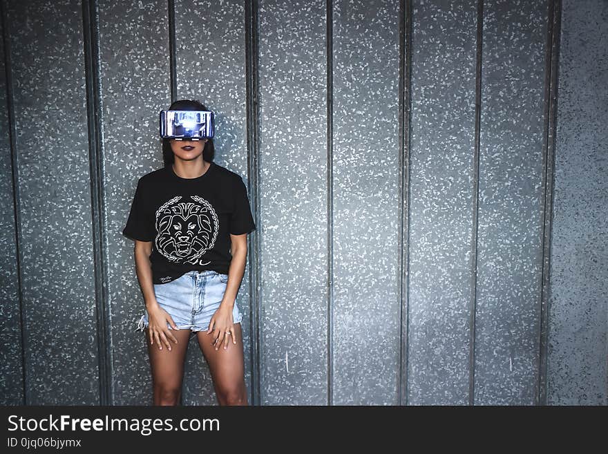 Woman in Black T-shirt Standing Near Gray Wall