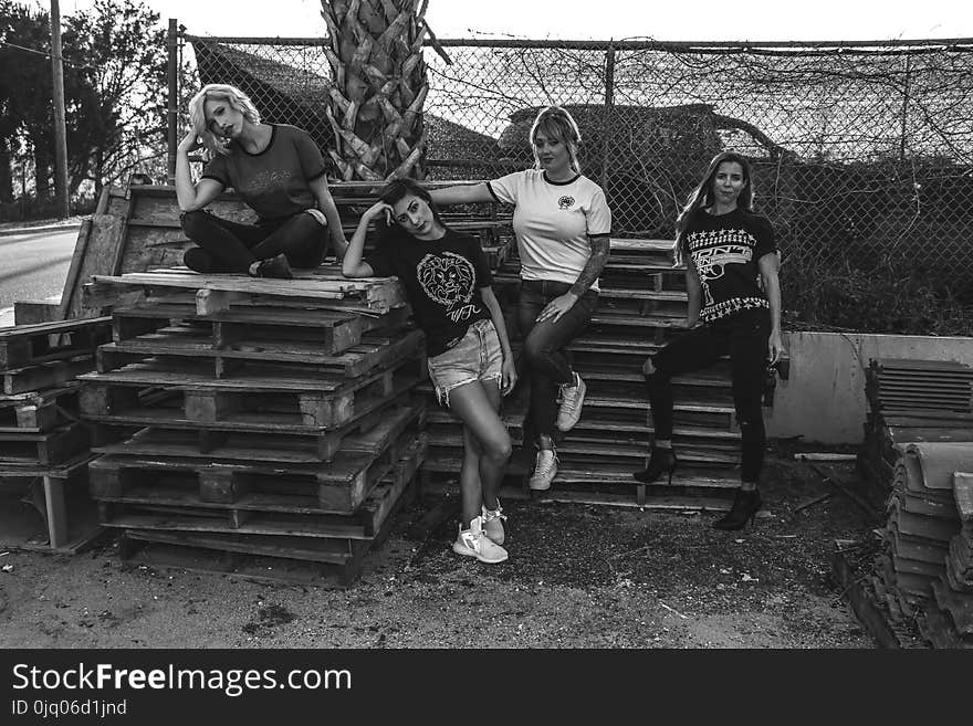 Four Women Leaning and Sitting on Pallets