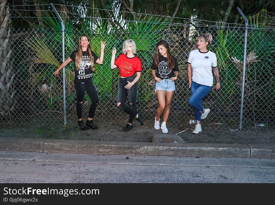 Group of Women Standing in Front Metal Fence