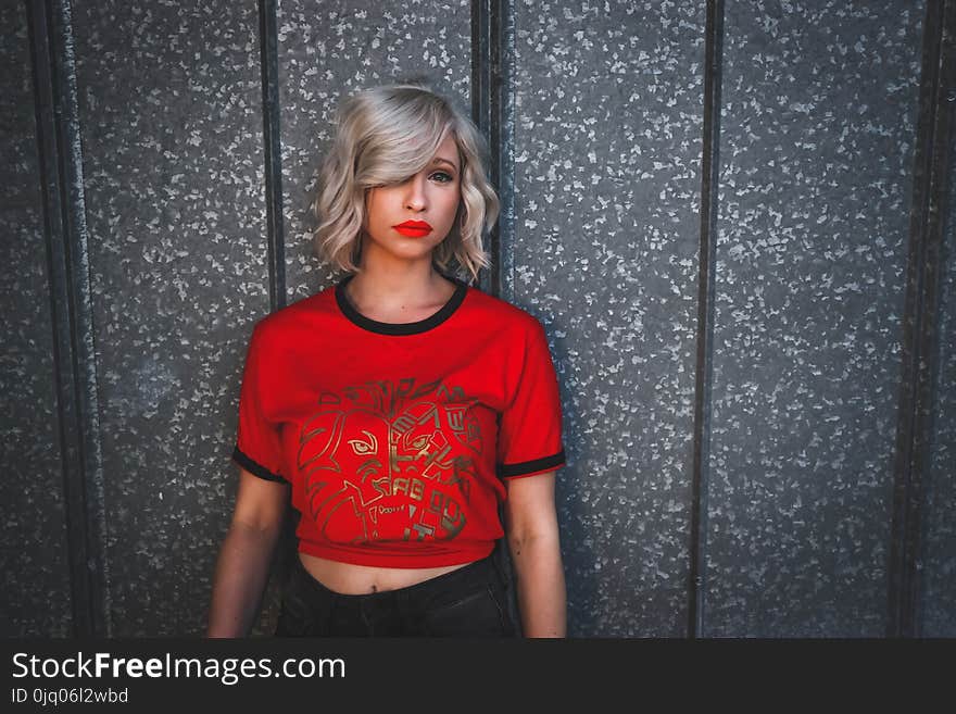 Woman in Red Shirt Standing Near Wall