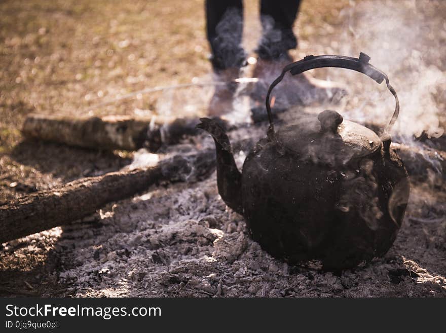 Kettle With Boiling Water over a Campfire.