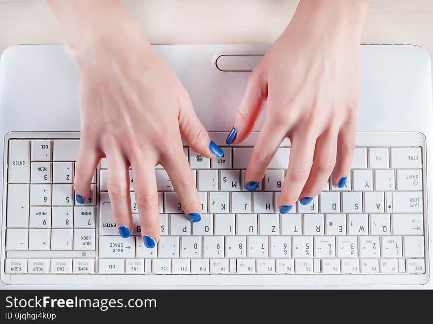 Female hands typing on white laptop keyboard. Top view, close up. Business and Education concept image