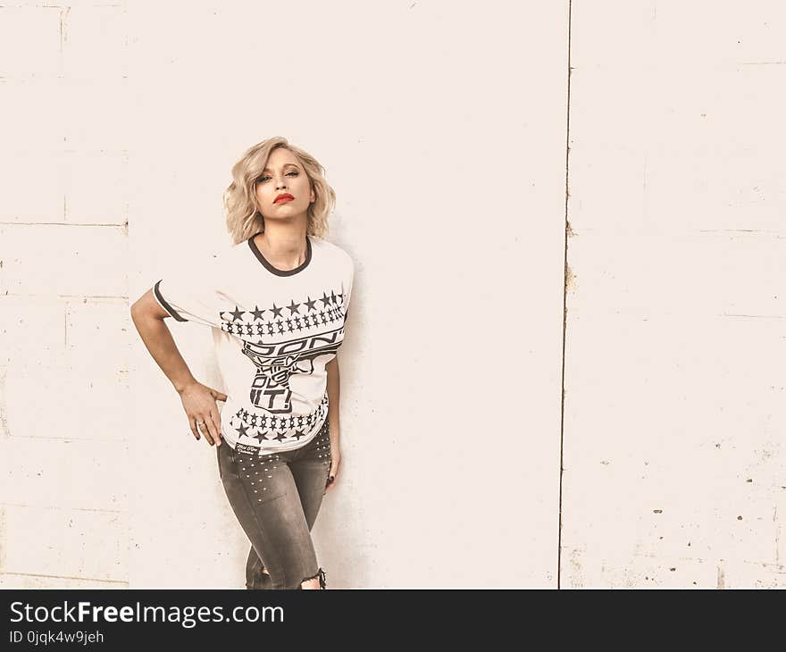 Woman With Blond Hair Wearing Whit Crew Neck Shirt and Gray Jeans