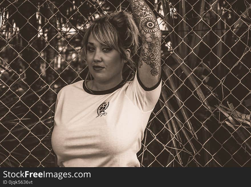 Women in White T-shirt Standing Near Fence