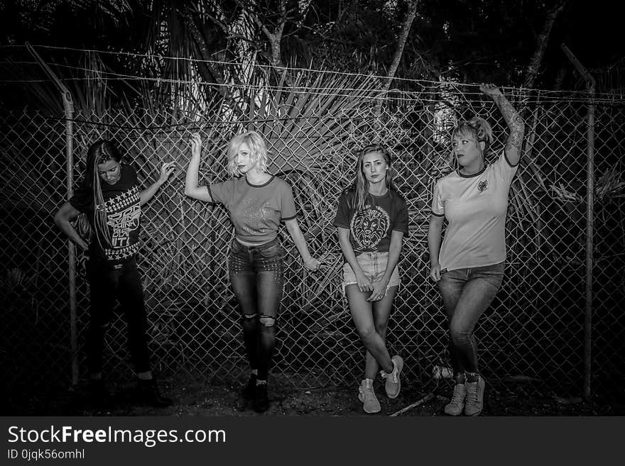 Four Women Standing Near Chain Fence