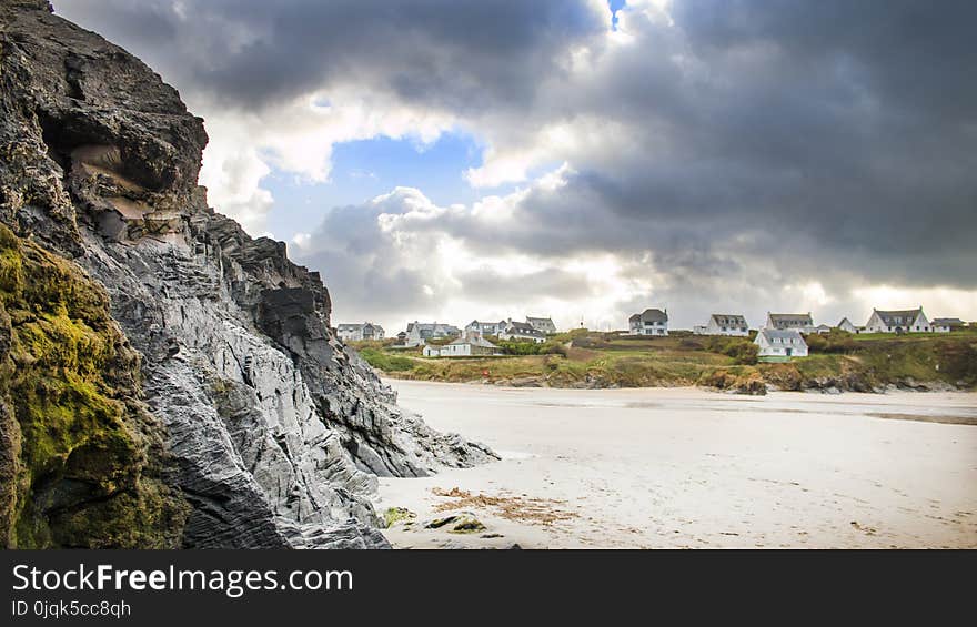 White Sand Beside Grey Rock Cliff