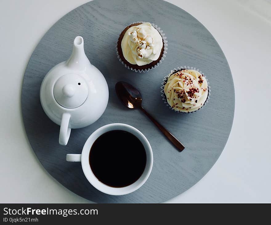 White Ceramic Cup and Teapot with Cupcakes