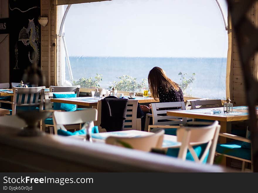 Woman Sitting on Chair With View of Sea