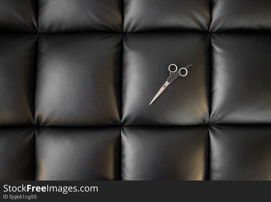 Photo of Scissor on Black Leather Cushion