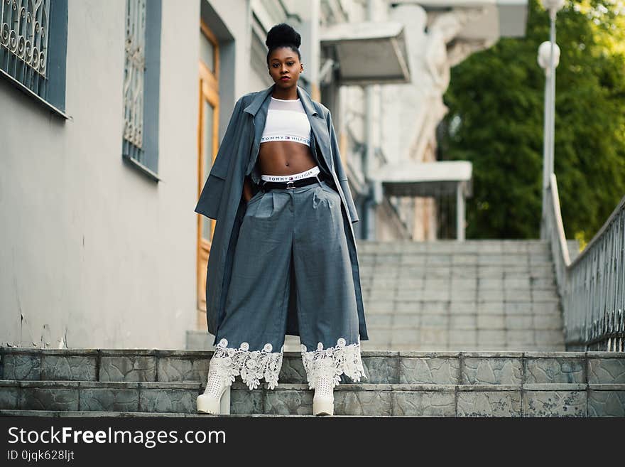 Woman Wearing Gray Coat and White Crop Top on Staircase