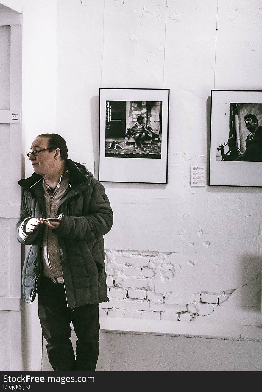 Man Standing in Front of Grayscale Gallery Photo