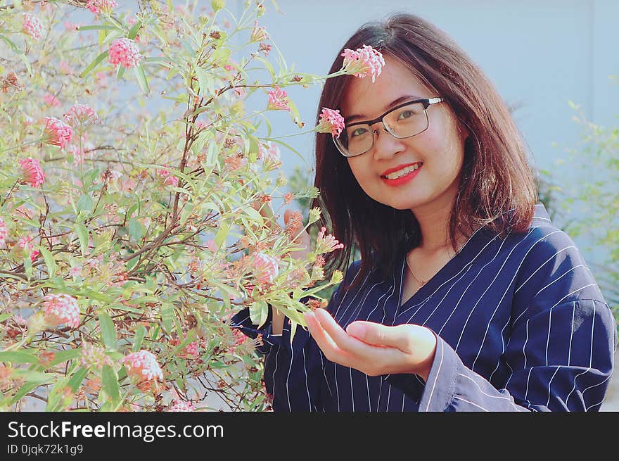 Woman in Blue Striped Top Holding Pink Flowers