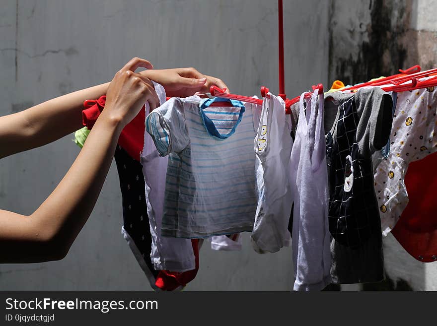 Drying clothes, the woman`s hand is holding the clothes to be dried, version 1. Drying clothes, the woman`s hand is holding the clothes to be dried, version 1