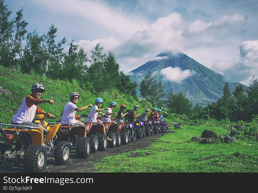 Line Of Men Riding On All Terrain Vehicles Holding Out Hand In A Fist