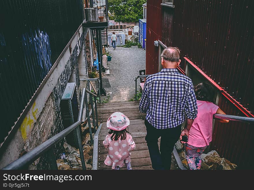 Man and Two Girls Walking Down on Stairs