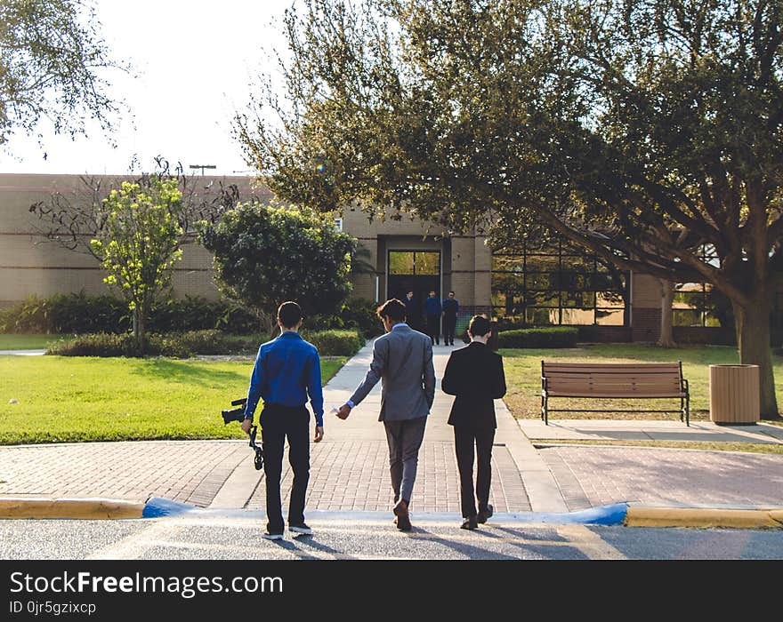 Three Man Walking on Street Wearing Suit Jackets