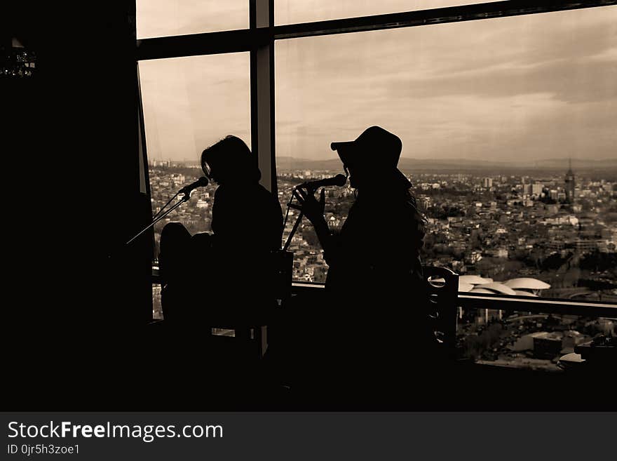 Silhouette of Two Women Singing in Sepia Photography