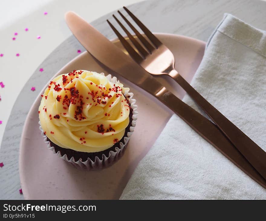 Silver Fork and Knife on Round Plate With Cupcake