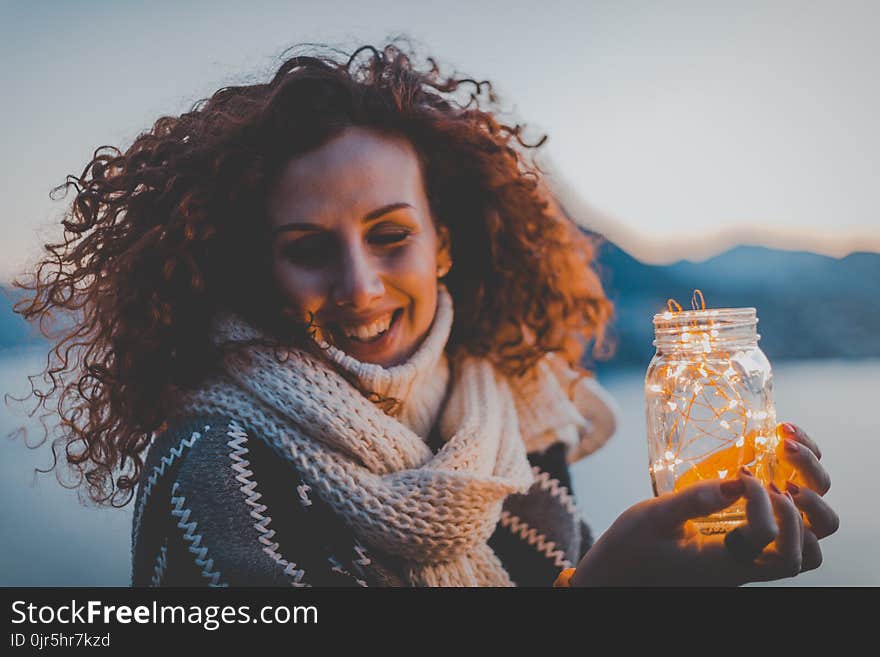 Woman Holding Lighted Jar Smiling