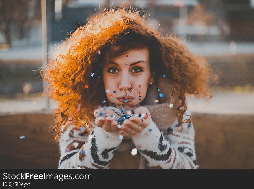 Woman in White and Black Sweater Blowing Confetti