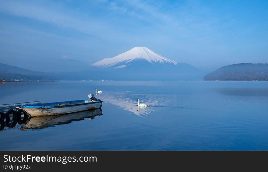 A small boat at a port with morning mist and FujiSan