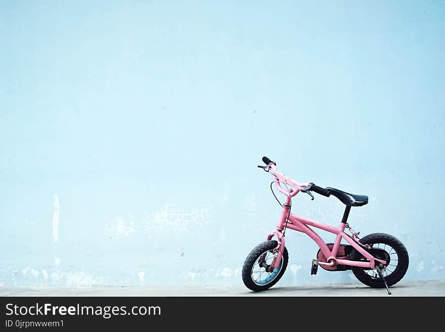 Toddler&#x27;s Pink Bike Near Wall