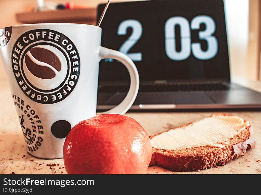 Closeup Photo of White and Black Printed Ceramic Mug Beside Pastry