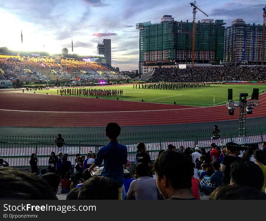 Group of People Watching Football Player Team on Field