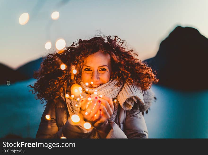 Woman Holding Brown Light during Nighttime