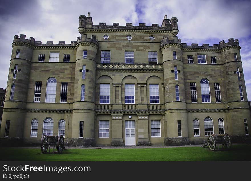 Low Angle Photo of Brown Castle Surrounded by Green Grass