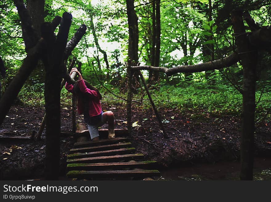 Girl in Pink Jacket on Wooden Bridge in the Forest