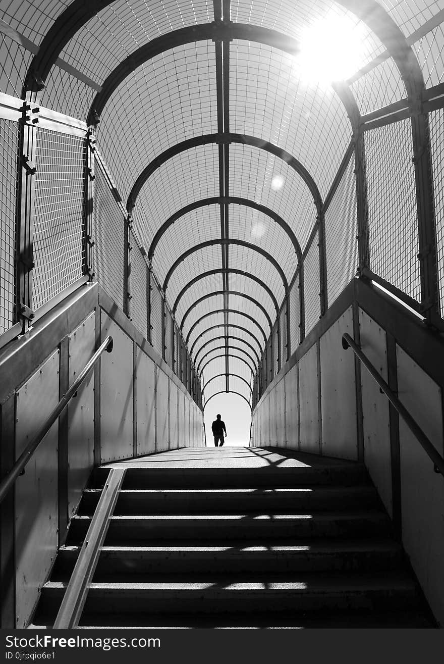 Person Standing Inside Arch Building