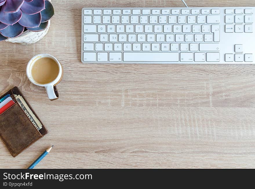 Cup of Coffee Near Keyboard on Table Top