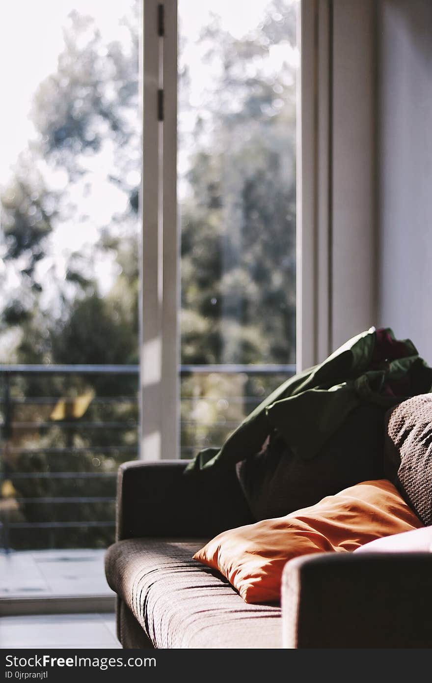 Brown Couch Beside Clear Glass Panel Door