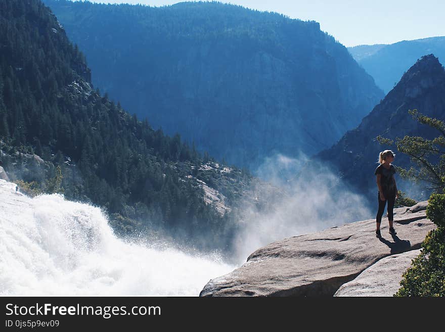 Woman Standing Near Mountain Cliff