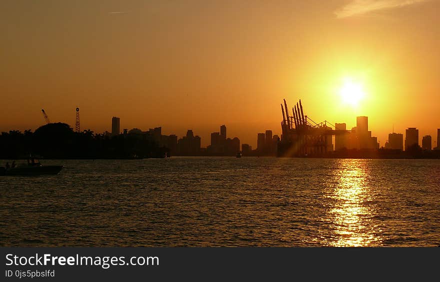 Silhouette of Buildings Near Body of Water Under Golden Hour