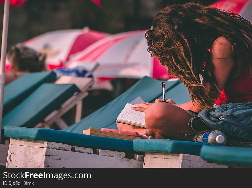 Woman With Red Top Holding Pen and Notebook