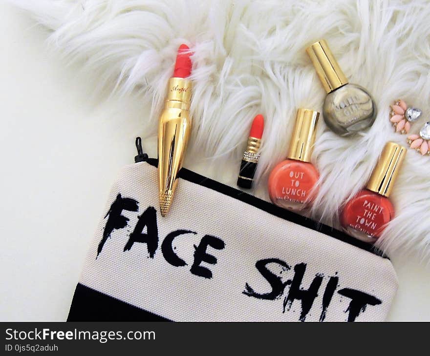 Photo of Two Red Lipsticks and Three Assorted-color Nail Polish Bottles