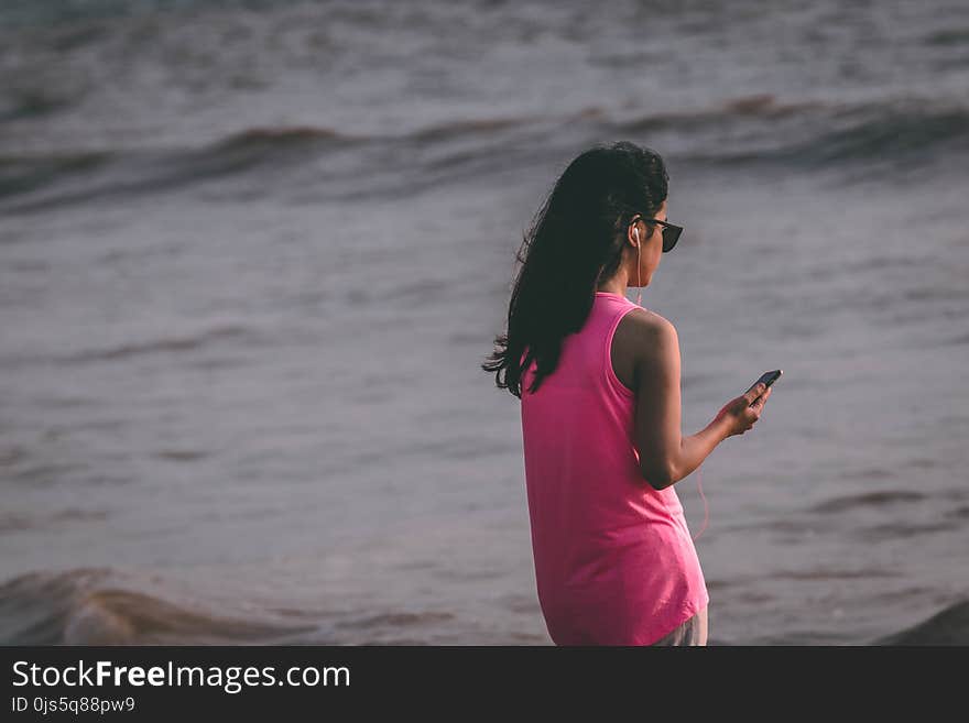 Woman Wearing Pink Tank Top Standing Near Sea Shore