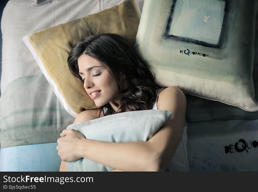 Woman Wearing White Tank-top Sleeping on Gray and White Bedspread