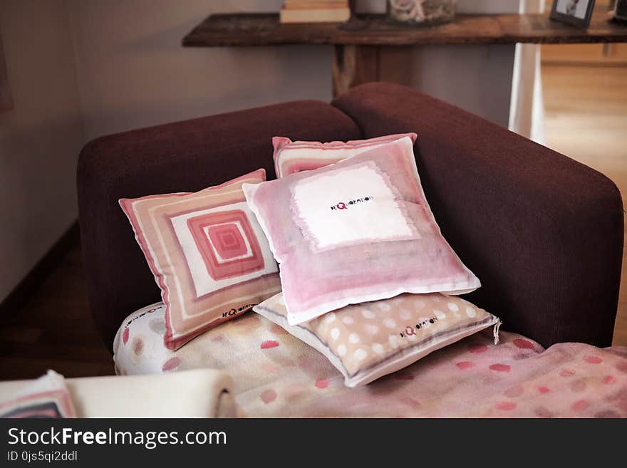 Four Assorted-color Throw Pillows on Padded Red Sofa