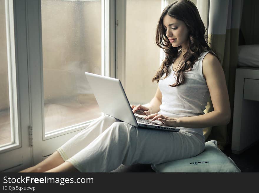 Woman Wearing Tank Top Sitting by the Window