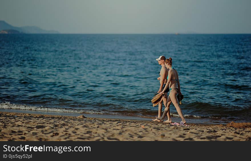 Couple Walking on the Beach at Daytime